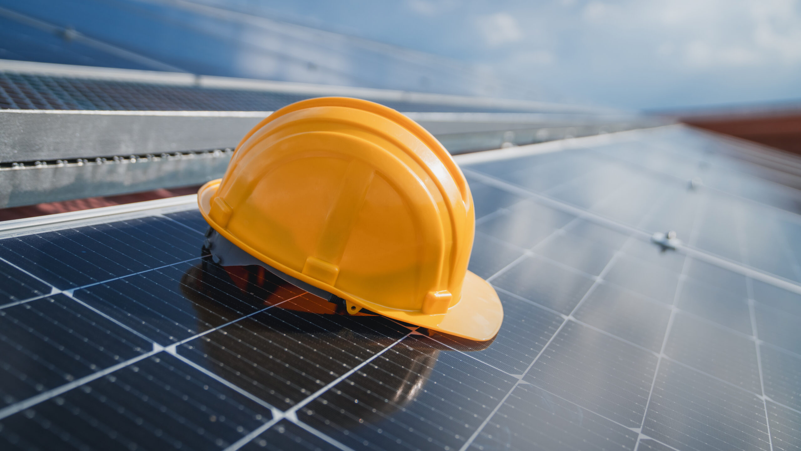 żółty kask na panelach fotowoltaicznych