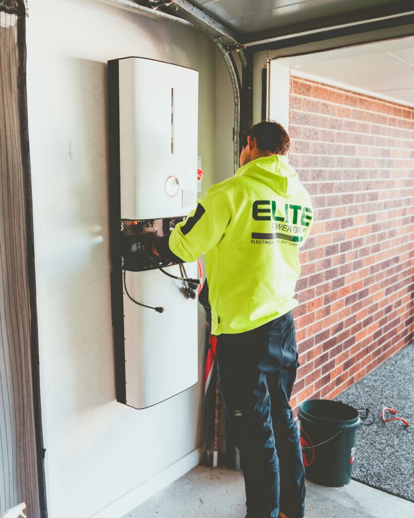 Elektryk sprawdzający okablowanie przy falowniku instalacji fotowoltaicznej