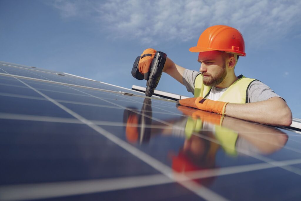 Instalator montujący panel fotowoltaiczny na dachu